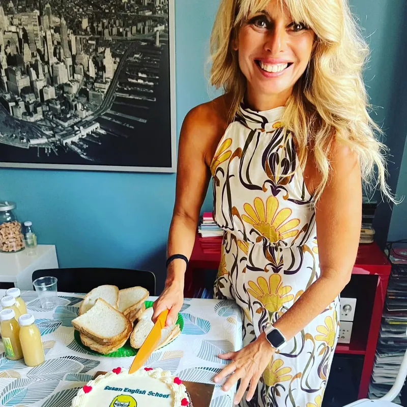 Taglio della torta con il logo della Susan English School durante una festa a scuola